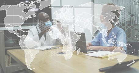 Adjusting mask, doctor lab coat, nurse blue scrubs typing, gesturing at meeting table, laptop map