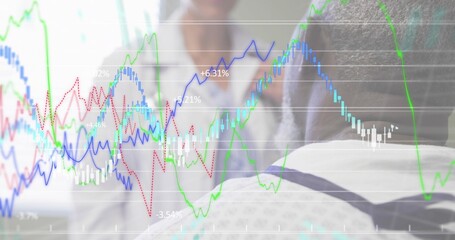 Analyzing exec in dark suit leaning at glass screen in office, showing financial charts, copy space