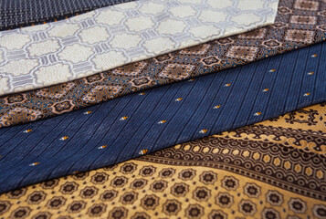 Full frame texture of colorful tie fabrics. Assortment of silk neckties with diverse motifs like stripes and batik, perfect for menswear fashion concepts
