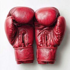 Close-up studio shot of two vibrant red leather boxing gloves placed side by side against a stark white backdrop