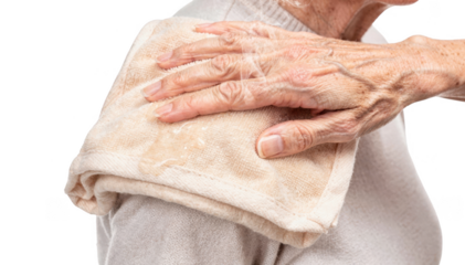 Closeup of a warm cloth compress gently applied on clothed skin of an elderly person with caregivers hand offering comforting support isolated on white background.