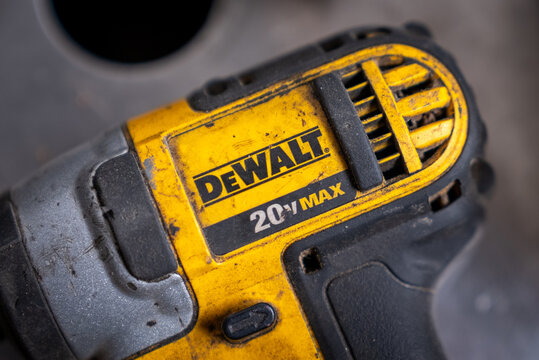 Close-up detail of a DEWALT 20V MAX cordless power tool showing signs of wear and heavy use, highlights rugged construction, industrial design, and professional-grade equipment.
