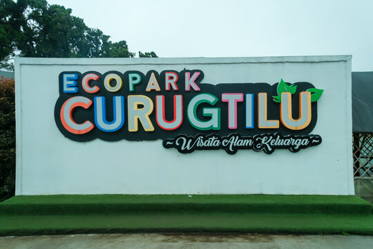Bandung-Indonesia, 9th January, 2026 - Colorful sign Eco Park Curug Tilu on a white wall at an outdoor nature park entrance with green trees in background.