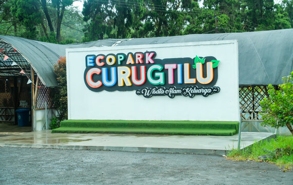 Bandung-Indonesia, 9th January, 2026 - Colorful sign Eco Park Curug Tilu on a white wall at an outdoor nature park entrance with green trees in background.