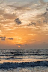 The vibrant colors of the sunset on the ocean surface create a tranquil scene.