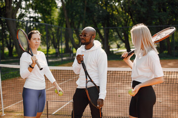 Two women and black race trainer at tennis court