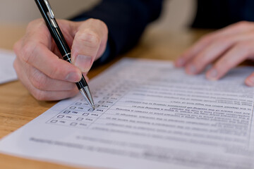 business approval and legal documentation concept. Contract agreement, compliance process, audit review, decision making and formal paperwork.Close-up of hand signing checklist form with pen