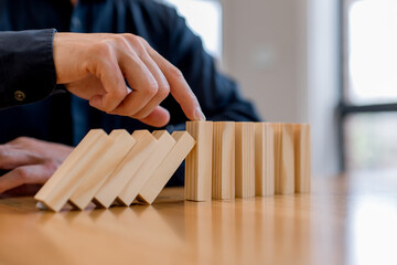 risk management and business protection concept. Preventing failure, stability control, crisis prevention, strategic planning and leadership decision making,Hand stopping falling wooden blocks