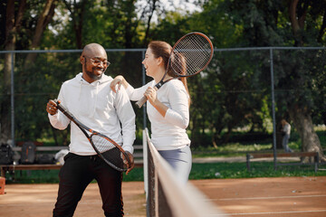 Black man talking with woman at tennis court
