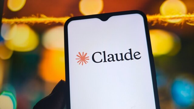 A smartphone displays the Claude logo on its screen with a blurred background of colorful lights.