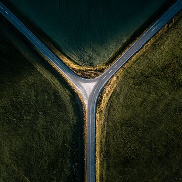 Top View Aerial Shot of Road Y-Junction Surrounded by Lush Green Fields