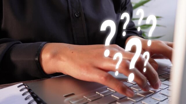Close-up of a businesswoman's hands typing on her personal computer with an animation of several white question marks