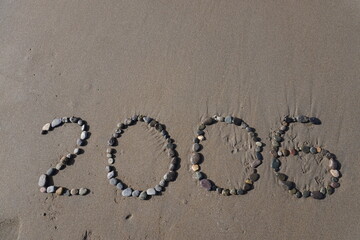 The stones arranged neatly on the beach form the number 2006