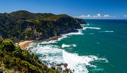 Fototapeta premium Stunning coastal landscape featuring cliffs, ocean, and a beautiful beach under a bright blue sky.