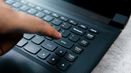Finger pressing the enter key on the keyboard