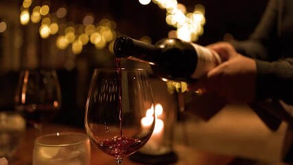 Sommelier Pouring Red Wine into Glass During Intimate Candlelit Dinner