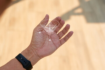 Abstract awareness signal visualization above human hand with smart wearable concept