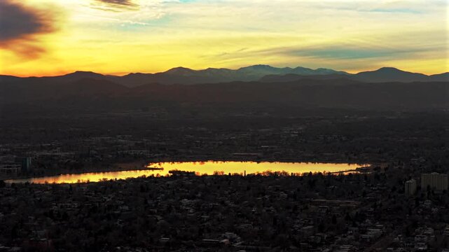 Front Range Rocky Mountains foothills Denver suburbs winter vibrant sunset Sloans Lake Park aerial drone Colorado neighborhood homes buildings Wheatridge Arvada Golden Mount Blue Sky parallax circle