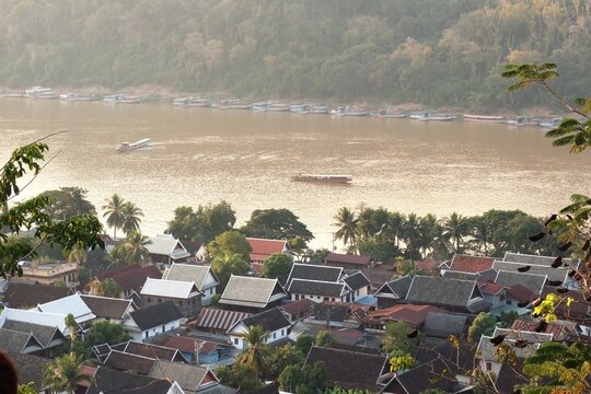 Panoramic view from Phousi Temple showing Luang Prabang&rsquo;s traditional houses, cultural atmosphere, and the Mekong River in a UNESCO World Heritage city.