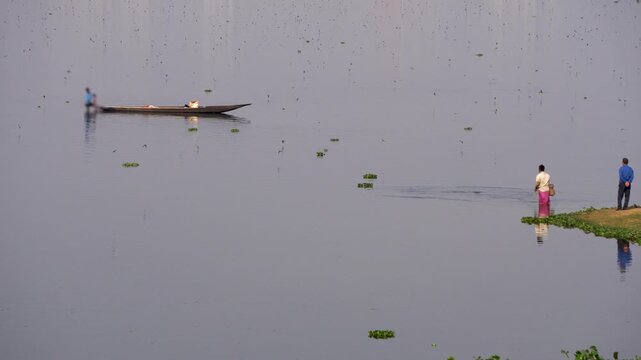 Shot of a fisherman catching fish with a fishing net at Deepor Beel Guwahati Assam with bird flying over the water 1
