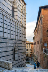 Naklejka premium Siena Cathedral side view and historic Siena street in Italy