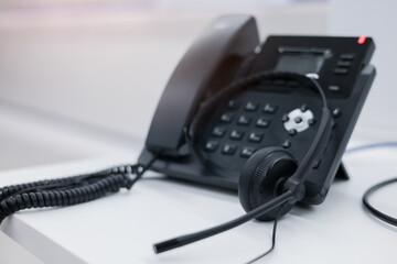 close up black headset with telephone in operation room to communicate with vendor or client for...