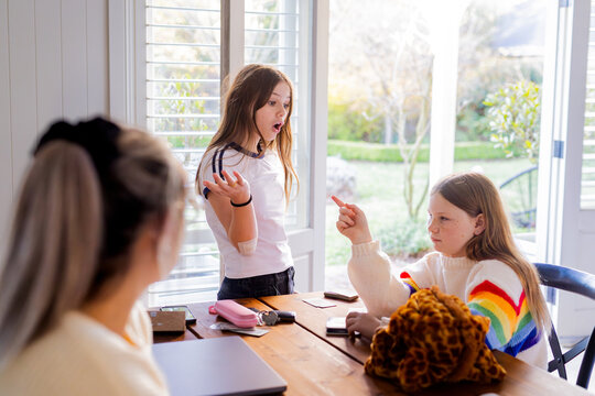 Young girls having a conversation on the table while playing cards
