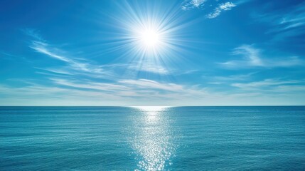 Obraz premium The intense glare of sunlight reflecting off the surface of the bright blue ocean under a clear sky with scattered clouds
