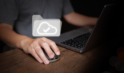 User clicking mouse beside laptop with cloud folder icon. Digital files, file management technology for business, paperless office, document workflow, cloud storage for productivity and remote work.