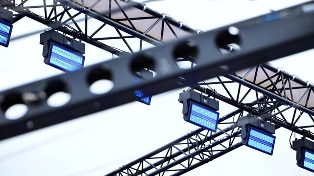 Stage lighting truss with LED spotlights illuminating event production rigging