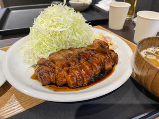 千切りキャベツとトンテキ。甘いタレをかけた豚肉の料理。