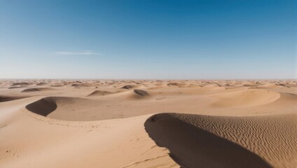 Vast expanse of beige sand dunes under a clear blue sky