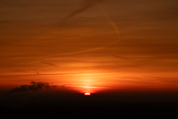Fiery orange sunset sky with dramatic clouds and copy space