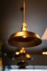 Obraz premium A classic style ceiling lighting lamp with iron cage during it glowing in warmlight shade. Interior object, close-up with selective focus.