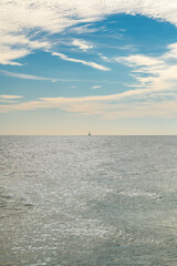 Obraz premium Sea with calm summer sky background. Sea calm with sunlight. Sea smooth and bright. Sea with soft clouds.