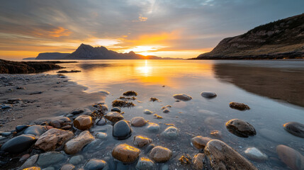 Obraz premium Golden hour sunset at rocky beach with wet stones reflecting warm light and calm water creating peaceful and serene coastal landscape