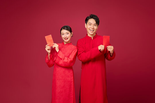 an Asian couple presenting red envelopes, designed with layout flexibility in mind, blank space for design your logo. Happy new year concept