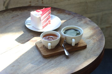 Cake and hot coffee on a wooden table.