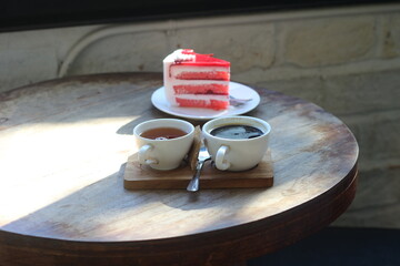 Cake and hot coffee on a wooden table.