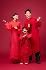 Fototapeta premium Designed for celebration themes, this image captures an Asian family using expressive gestures and bright smiles. Mom and dad holding red lucky envelopes