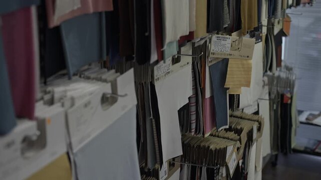 rows of fabric swatches displayed on hanging racks indoors