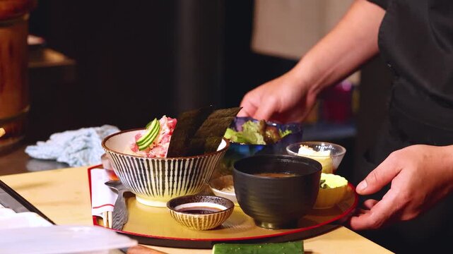 Japanese Chef in Black Uniform Serving Traditional Chirashi Bowl and Miso Soup
