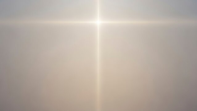 A blurred image shows a bright central light source forming a cross shape on a gray and tan gradient background