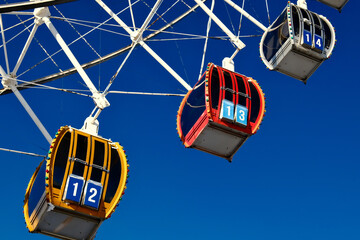 Colorful Ferris wheel cabins close up, amusement park ride details