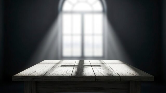 A wooden table with a cross shadow illuminated by a bright window in a dark room
