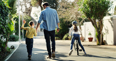 Father, children and holding hands in street with walk, bicycle and activity for bonding together. Back, dad and kids stroll outdoor in neighborhood with support, bike and care for family connection.