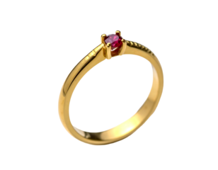 Elegant gold ring featuring a single, small, deep red gemstone