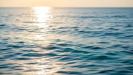 Sunlit ocean rippled water surface reflecting light calm sea horizon visible