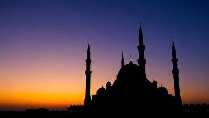 Mosque silhouette against a vibrant gradient sunset sky