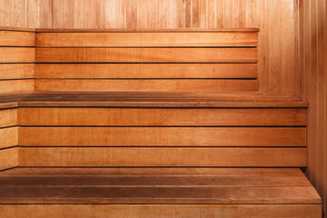Wooden benches inside a sauna with warm lighting in a relaxing space